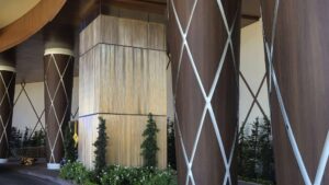 Modern woodgrain column wrap by Engineered Group in corporate office lobby.